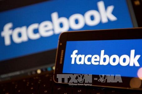 Biểu tượng Facebook trên màn hình điện thoại và máy vi tính. Ảnh: AFP/TTXVN