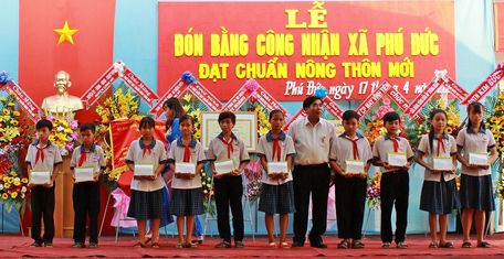Ông Trần Thanh Lâm- Phó Chủ tịch UBMTTQ Việt Nam tỉnh Vĩnh Long trao quà và học bổng cho các em học sinh trong xã.