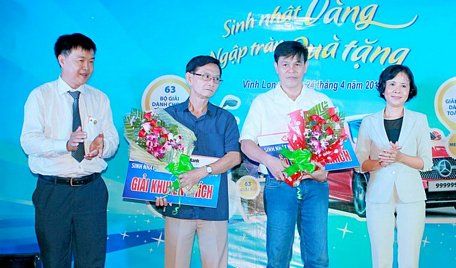 Ông Nguyễn Thanh Tùng- Phó Tổng Giám đốc LienVietPostBank (trái) và bà Trương Thị Oanh- Phó Giám đốc Ngân hàng Nhà nước Việt Nam chi nhánh Vĩnh Long trao giải khuyến khích cho khách hàng trúng thưởng.