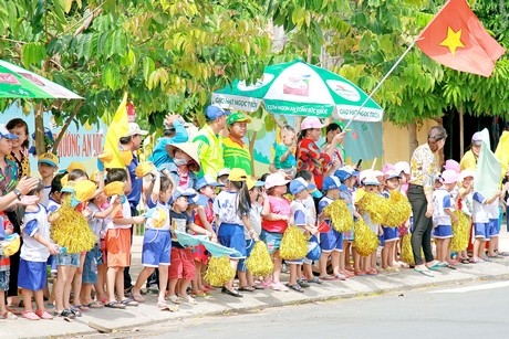 Các học sinh mầm non tại TX Hồng Ngự chào đón đoàn đua về đích. Ảnh: THẾ HUY