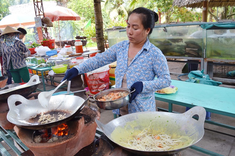 Đầu bếp đang đổ bánh xèo phục vụ khách du lịch.