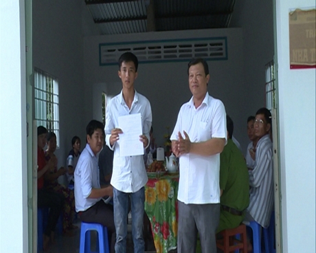 Lãnh đạo địa phương trao quyết định bàn giao nhà tình thương cho em Nguyễn Thanh Nguyên mồ côi cha lẫn mẹ.