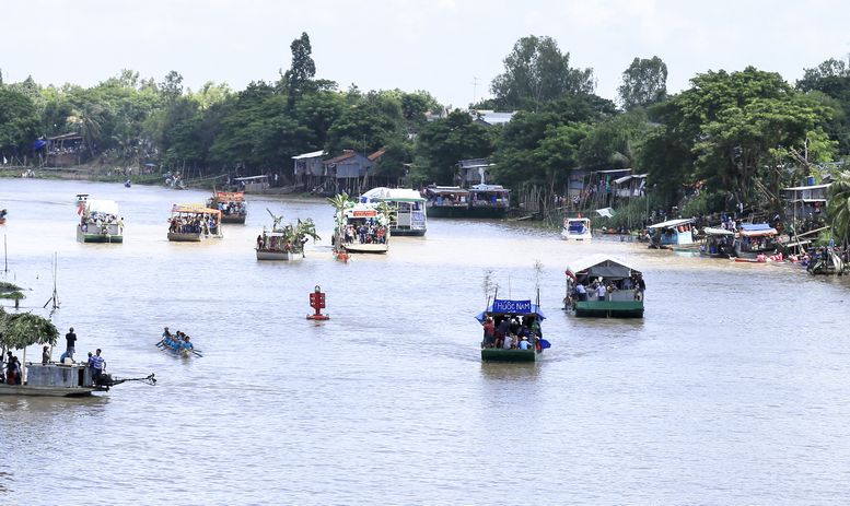 Nhiều chiếc thuyền được trang trí sinh động chạy dọc trên sông để cổ vũ cho các đoàn đua.