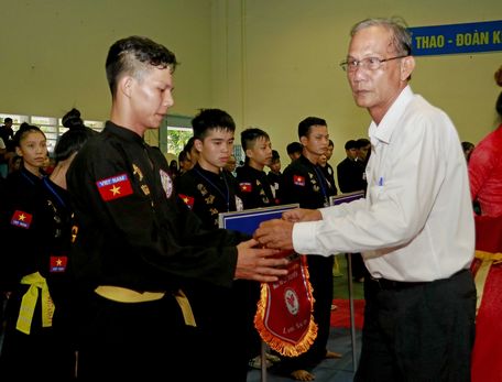  Nguyễn Thanh An- Phó Giám đốc Sở Văn hóa, Thể thao và Du lịch kiêm Chủ tịch Liên đoàn Võ thuật tỉnh Vĩnh Long trao cờ lưu niệm cho các đơn vị tham dự giải.