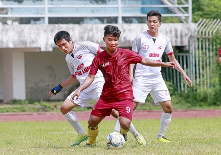 Pha tranh bóng trong trận giữa TP Vĩnh Long (áo trắng) thắng Tam Bình 2-1.