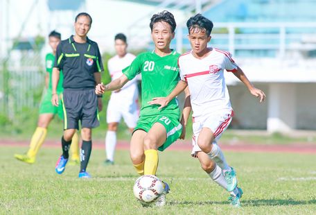 Tự Nhân (20, Vĩnh Long, áo xanh) đi bóng trước Văn Phi (24, Đồng Nai).