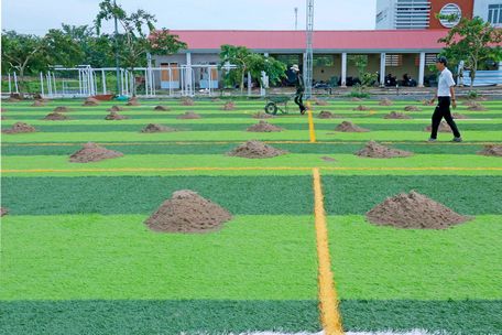 Nhân viên thi công giai đoạn cuối trên mặt sân.