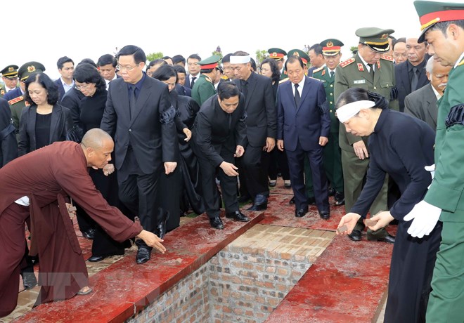  Lãnh đạo, nguyên lãnh đạo Đảng, Nhà nước, Mặt trận Tổ quốc Việt Nam và gia đình Chủ tịch nước Trần Đại Quang thả những nắm đất đầu tiên xuống huyệt mộ Chủ tịch nước. (Ảnh: Nhan Sáng/TTXVN)