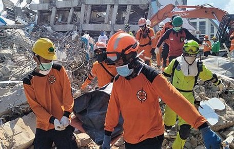 Lực lượng cứu hộ đưa thi thể nạn nhân ra khỏi đống đổ nát. Ảnh: AP.