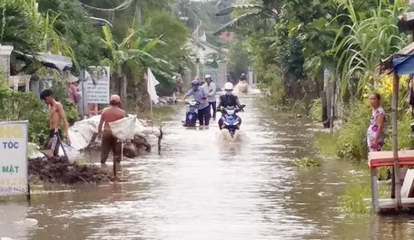 Chiều 7/10, nhiều xe máy lưu thông trên đoạn từ UBND xã Tân Lộc ra Quốc lộ 1A (Hòa Phú) bị nước làm tắt phải dẫn bộ.