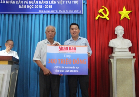 Các em học sinh được nhận học bổng “Quỹ Hạt giống Việt”.Đại diện lãnh đạo Ngân hàng TMCP Bưu Điện Liên Việt chi nhánh Vĩnh Long trao tượng trưng học bổng cho Hội Khuyến học tỉnh.