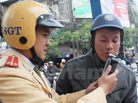 Cảnh sát giao thông tiến hành đo nồng độ cồn của người điều khiển phương tiện. (Ảnh: Việt Hùng/Vietnam+)