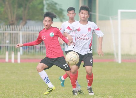 Pha tranh bóng trong trận Trẻ Vĩnh Long (áo đỏ) gặp Trẻ Long An.