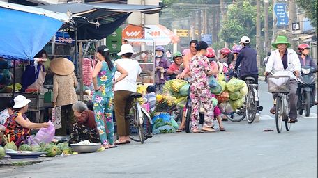 Cảnh lấn lề đường họp chợ tự phát ở Phường 5 tiềm ẩn nhiều nguy cơ mất an toàn giao thông.Ảnh: Tấn Phát