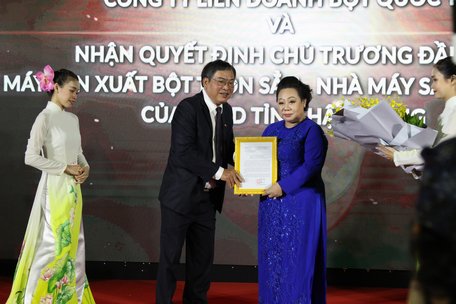 Phó Chủ tịch UBND tỉnh Hậu Giang Nguyễn Văn Tuấn trao quyết định đầu tư máy sản xuất bột trộn sẵn và nhà máy sản xuất bột gạo cho bà Huỳnh Kim Chi- Tổng Giám đốc Công ty liên doanh bột quốc tế Intermix.