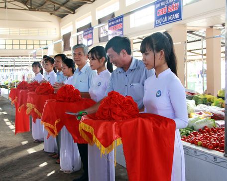 Các đại biểu cắt băng khánh thành mô hình chợ.