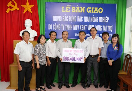 Ông Thiệu Ngọc Tâm- Chủ tịch kiêm Giám đốc Công ty TNHH 1TV Xổ số kiến thiết Vĩnh Long (người cầm bảng bên phải) trao tiền tượng trưng cho lãnh đạo Sở Nông nghiệp- PTNT Vĩnh Long.