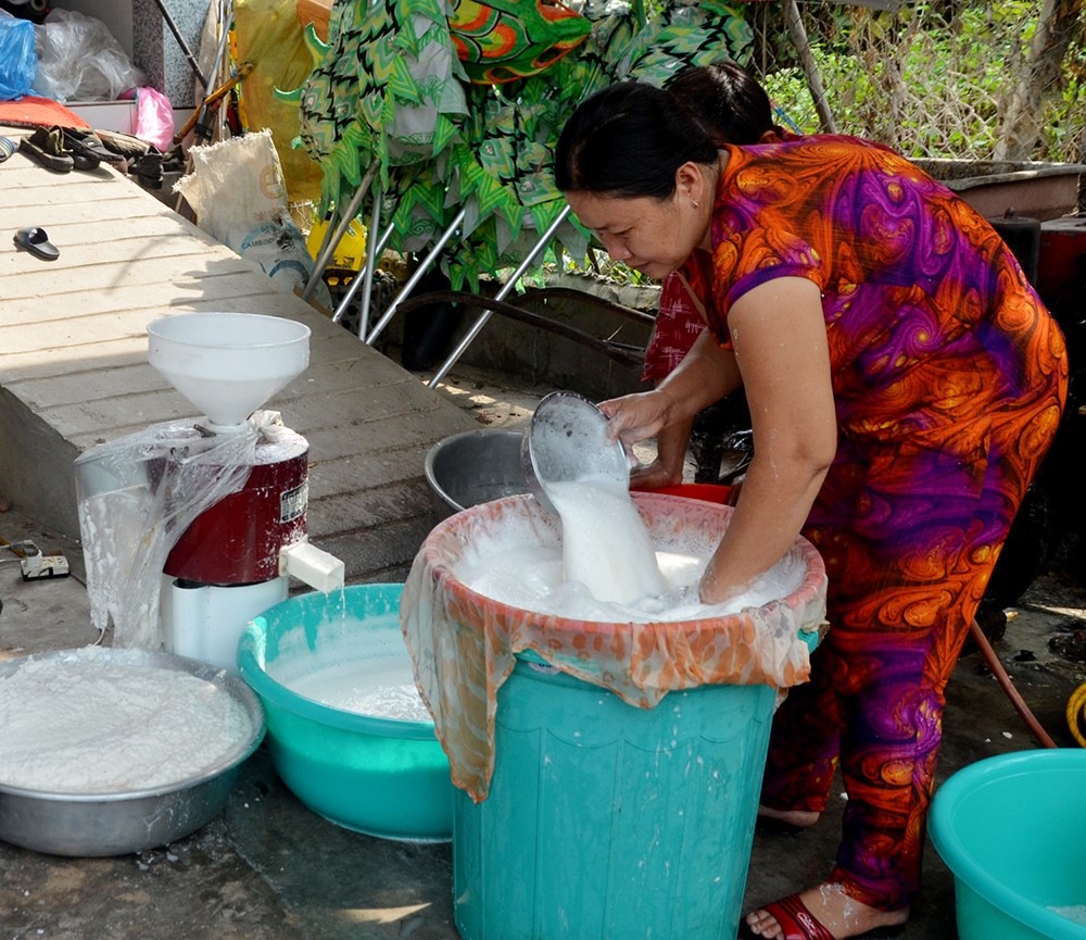 Gia đình ông Trần Văn Ký xay củ huyền làm bột