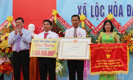 Đồng chí Trần Văn Rón- Ủy viên BCH Trung ương Đảng, Bí thư Tỉnh ủy trao cờ thi đua, bằng công nhận đạt chuẩn NTM và khen thưởng công trình phúc lợi trị giá 1 tỷ đồng cho xã Lộc Hòa. 