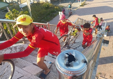 Không qua lộ được, các em này đang “cõng” xe đạp lên cầu đi bộ.