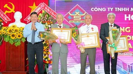 Đồng chí Trần Văn Rón- Bí thư Tỉnh ủy trao bằng khen Chính phủ cho các đại lý vé số của xổ số kiến thiết Vĩnh Long. Ảnh: DƯƠNG THU