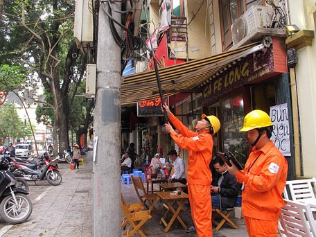   Nhân viên ngành điện đang chốt chỉ số công tơ của khách hàng. (Ảnh: Đức Duy/Vietnam+)