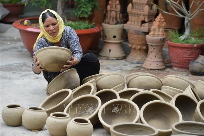 Những sản phẩm gốm Bàu Trúc (Ninh Thuận) được các nghệ nhân nhào nặn ra bằng những đôi tay khéo léo mà không cần phải dùng bàn xoay để tạo hình, người nghệ nhân sẽ đi vòng quanh rất nhiều lần để tạo ra một sản phẩm gốm. Ảnh: Trọng Đạt/TTXVN