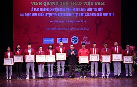 Ông Hoàng Vĩnh Giang, Chủ tịch Ủy ban Olympic Việt Nam trao tặng Bằng khen cho các HLV, VĐV tiêu biểu năm 2018. Ảnh: Trọng Đạt/TTXVN