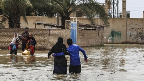 Người dân di chuyển khó khăn trong mưa lũ. Ảnh: BBC