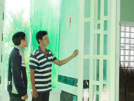 Anh Dũng vui vẻ bên căn nhà đại đoàn kết mới cất xong.