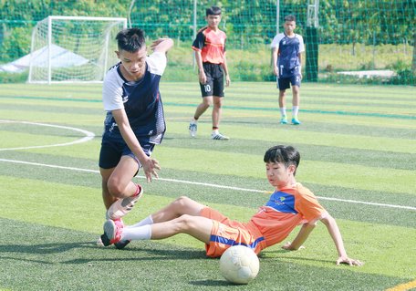 Pha tranh bóng trong trận Justin Phúc (áo cam) thắng Nắng mưa FC 5-2.