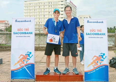 VĐV Cao Hồng Sơn (trái) nhận huy chương hoàn thành cự ly 5km.  