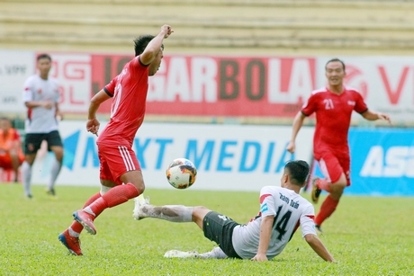 Pha tranh bóng trong trận Long An (áo trắng) thua Vĩnh Long 1-3.