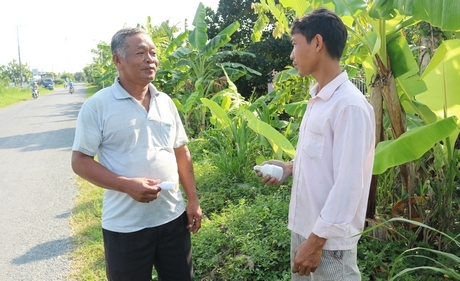 Chú Thạch Quơn (trái) cùng đi thay bóng đèn chiếu sáng trên Đường tỉnh 907 (xã Tân Mỹ- Trà Ôn).