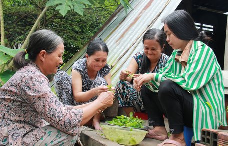 Cô Hoàng (trái) dạy các con lặt rau.