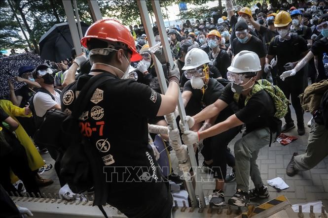 Những người biểu tình quá khích phá hàng rào để tràn vào tòa nhà cơ quan lập pháp ở Hong Kong, Trung Quốc, ngày 1/7. Ảnh: AFP/TTXVN