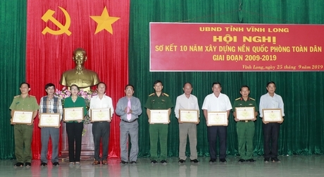 Ông Trần Hoàng Tựu- Phó Chủ tịch UBND tỉnh- trao bằng khen các tập thể, cá nhân có thành tích tiêu biểu trong xây dựng nền quốc phòng toàn dân.