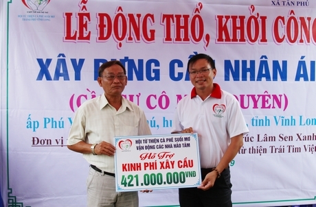 Anh Nguyễn Thanh Tuấn- Hội trưởng Hội từ thiện cà phê Suối Mơ trao 421 triệu đồng cho ông Lê Văn Sáu- Bí thư Đảng ủy xã Tân Phú.