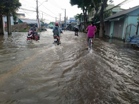 Người và xe chật vật trong con nước triều cường “lịch sử”.