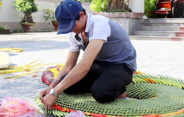 Để tạo nên những cổng cưới đẹp mắt, hàng ngàn trái ớt, đậu bắp, lá khóm, vảy quả khóm, hoa cúc, hoa lan… được nhóm của anh Ngọt kết thành những hình mẫu sinh động, mang ý nghĩa tốt đẹp chúc phúc cho đôi uyên ương.