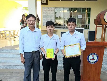 Thầy Trương Công Danh- Hiệu trưởng Trường THPT Mỹ Thuận (Bình Tân) trao thưởng cho hai em (ảnh trường cung cấp).