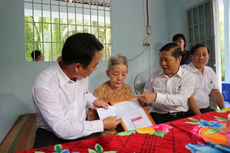 Thứ trưởng Bộ Lao động- Thương binh và Xã hội Lê Tấn Dũng (thứ 2 bên phải) và Phó Chủ tịch phụ trách UBND tỉnh Vĩnh Long Lữ Quang Ngời (bìa trái) thăm hỏi sức khỏe bà Trần Thị Dung- gia đình có công cách mạng ở ấp Tam Trung (xã Trung Ngãi).