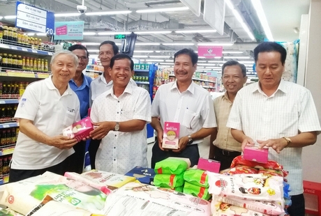 Ông Phạm Chánh Trực (bìa trái) cùng lãnh đạo xã Mỹ Lộc tham quan gian hàng gạo sạch tại Saigon Co.op (TP Hồ Chí Minh).