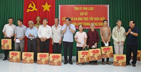 Đồng chí Bùi Văn Nghiêm- Phó Bí thư Thường trực Tỉnh ủy, Chủ tịch HĐND tỉnh (giữa) và đồng chí Nguyễn Văn Quang- nguyên Phó Bí thư Tỉnh ủy Vĩnh Long, nguyên Chủ tịch UBND tỉnh trao quà đến các hộ gia đình. 