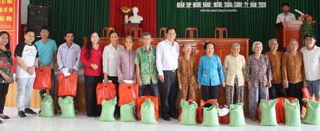 Đại biểu Quốc hội Lưu Thành Công (đứng giữa) và đại biểu Quốc hội Nguyễn Thị Minh Trang- Bí thư Huyện ủy Mang Thít (thứ 5, bên trái) cùng chính quyền địa phương và nhà tài trợ tặng quà gia đình chính sách xã Chánh Hội (Mang Thít).  