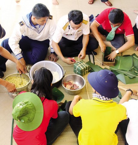 Đoàn công tác cùng chung tay gói bánh chưng tết với các chiến sĩ.