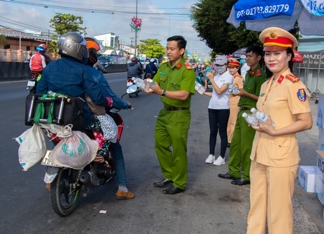 Lực lượng đoàn viên thanh niên Công an tỉnh tặng nước uống miễn phí cho người đi đường.