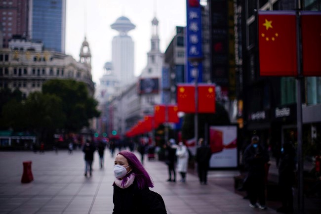 Một cô gái đeo khẩu trang trên đường phố Thượng Hải. Ảnh: Reuters