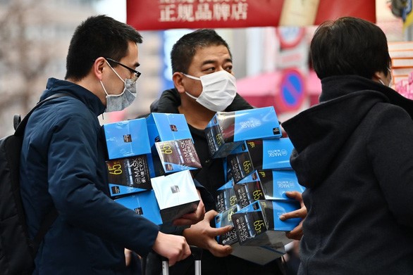 Khách gom hàng khẩu trang theo lố ở Tokyo, Nhật Bản - Ảnh: AFP