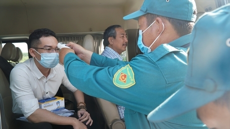 Đo thân nhiệt cho khách tại cổng vào Công ty TNHH Tỷ Bách đóng tại Khu công nghiệp Bình Minh. Ảnh: T.ANH